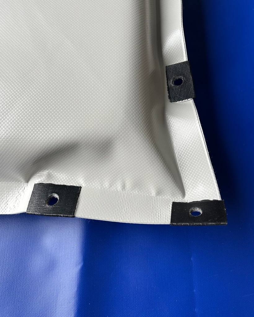 Ecke der Exto-Bac Klauenmatte mit zwei schwarz verstärkten Ösen
                    zur Fixierung im Stall